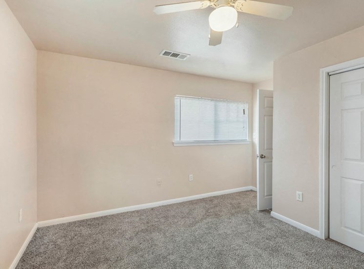 Bedroom with wall to wall carpet, window with blinds,  and ceiling fan